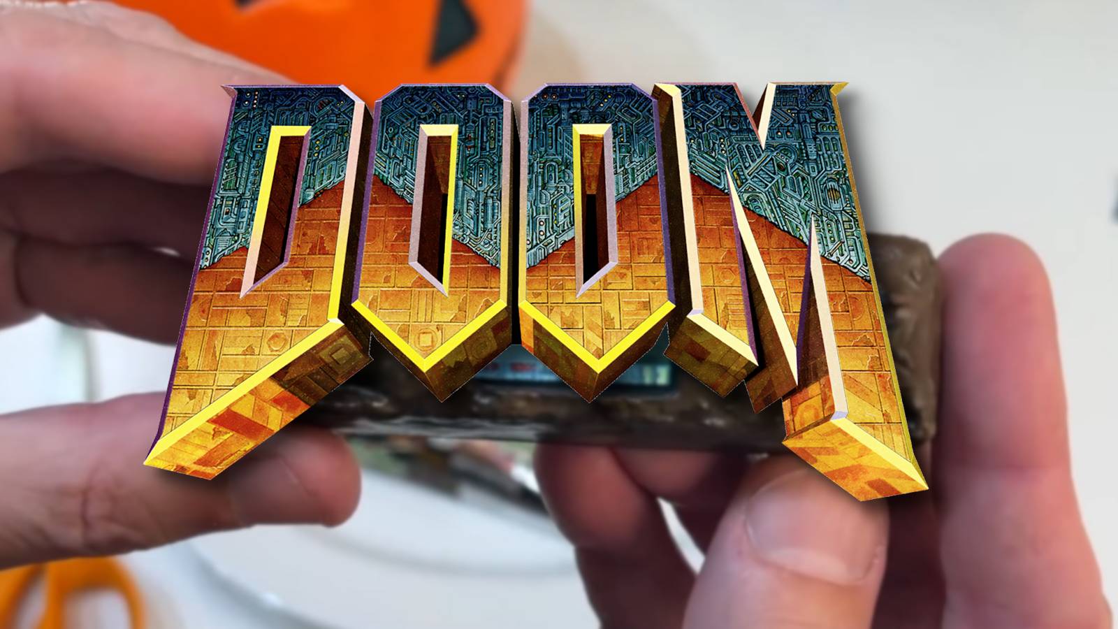 The Doom logo with a hand holding a fake chocolate bar behind it.