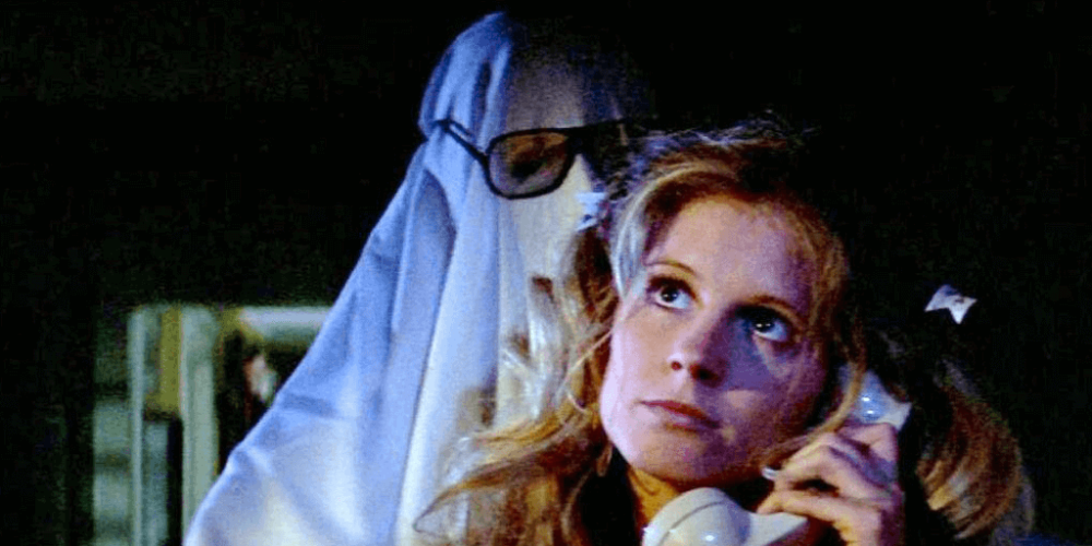 lynda on the phone with michael myers in a ghost sheet behind her