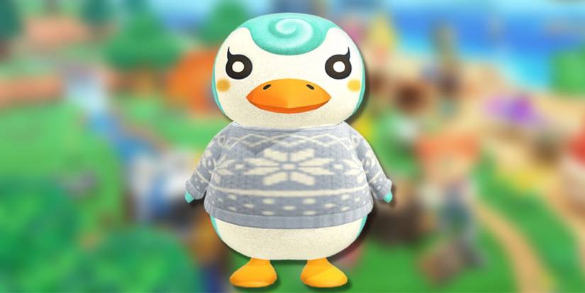 Sprinkle, a cream penguin with blue swirls, on a blurred green background.