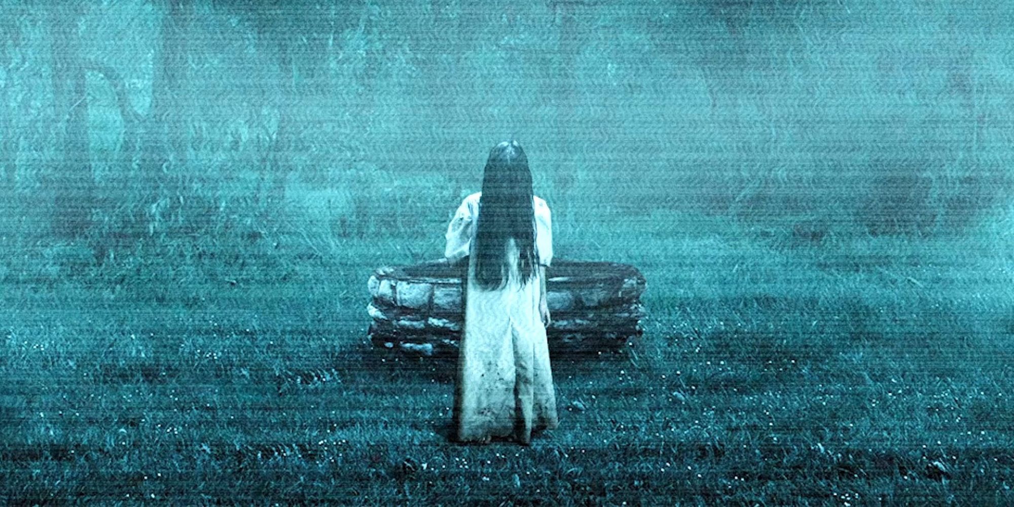 A screenshot of the movie The Ring (2002), featuring a grainy video feed of a girl with an obscured face walking towards the camera in front of a well.