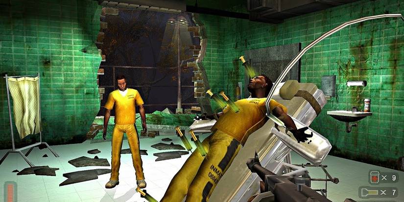 Two inmates are in a partially destroyed, one standing and looking at the other, strapped to an upright gurney, five green injections stuck in his body.