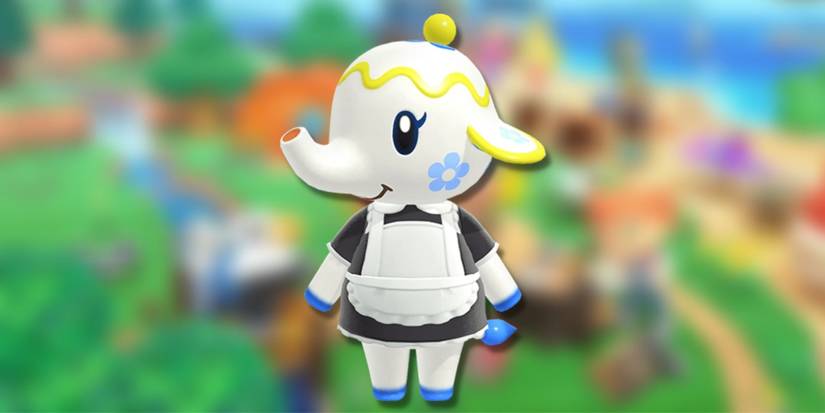 Tia, a white teapot themed elephant with a blue flower on her cheek, on a blurred green background.