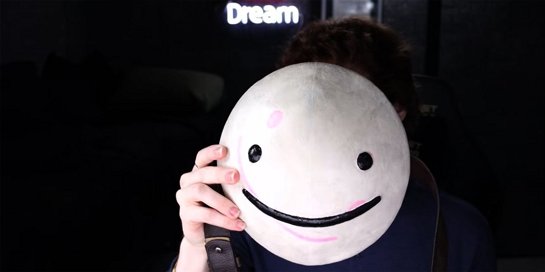 youtuber dream holding smiley face mask before face reveal