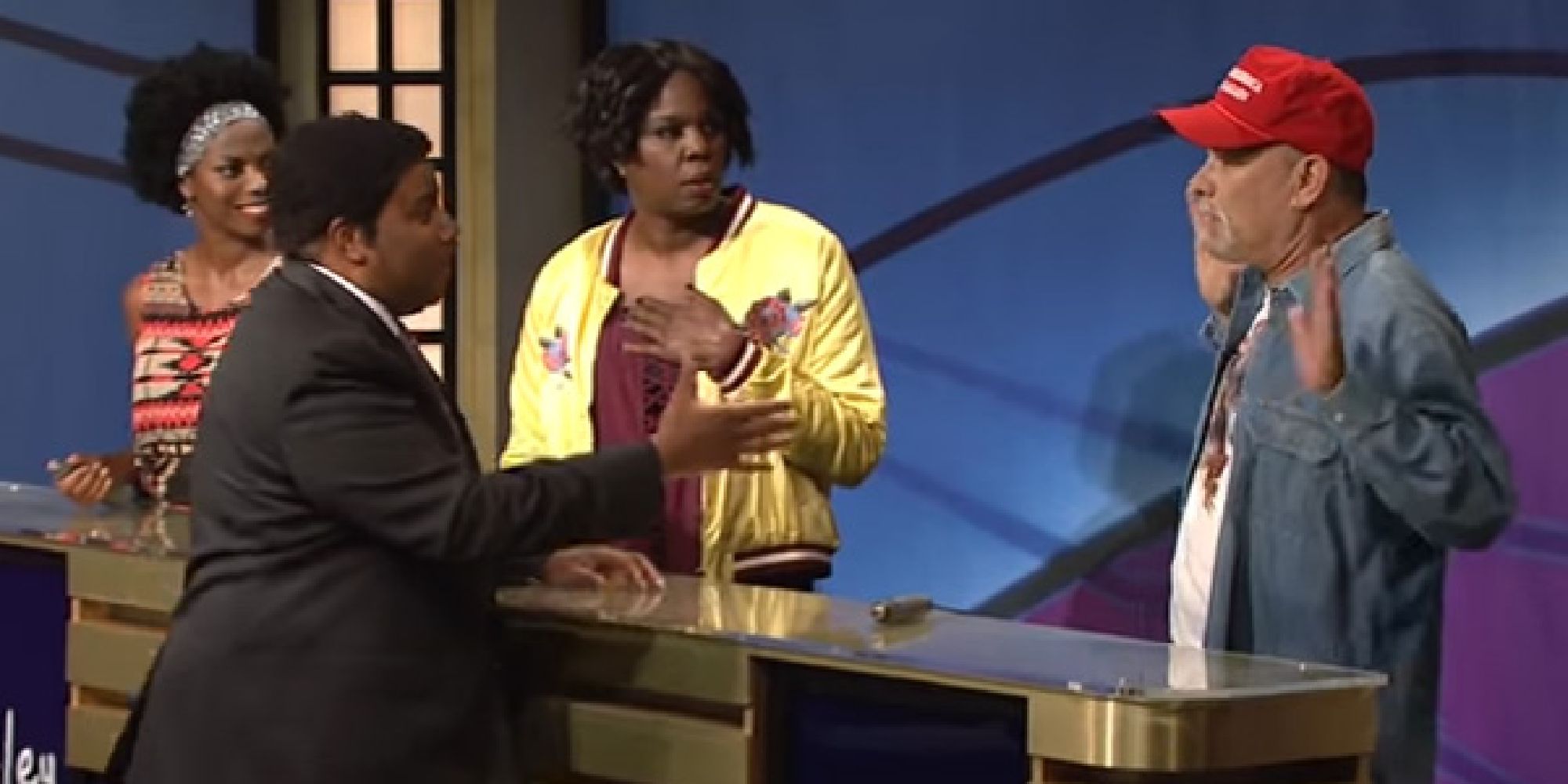Kenan approaching a frightened Tom Hanks in Black Jeopardy with Sasheer Zamata and Leslie Jones