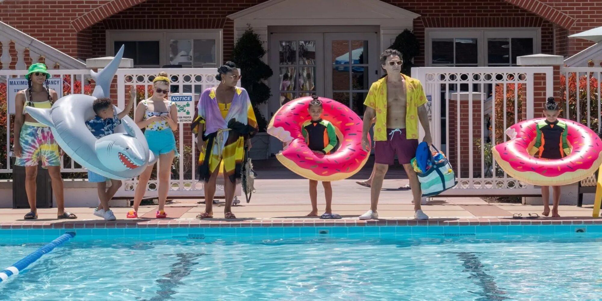 Zac Braff as Paul Baker standing with his children at the edge of a swimming pool at their new home