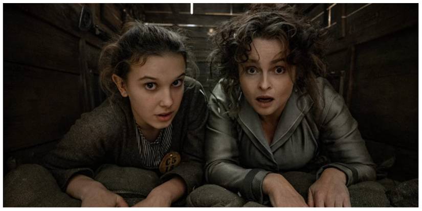 Enola Holmes and her Mother lying down in a carriage facing the camera in shock