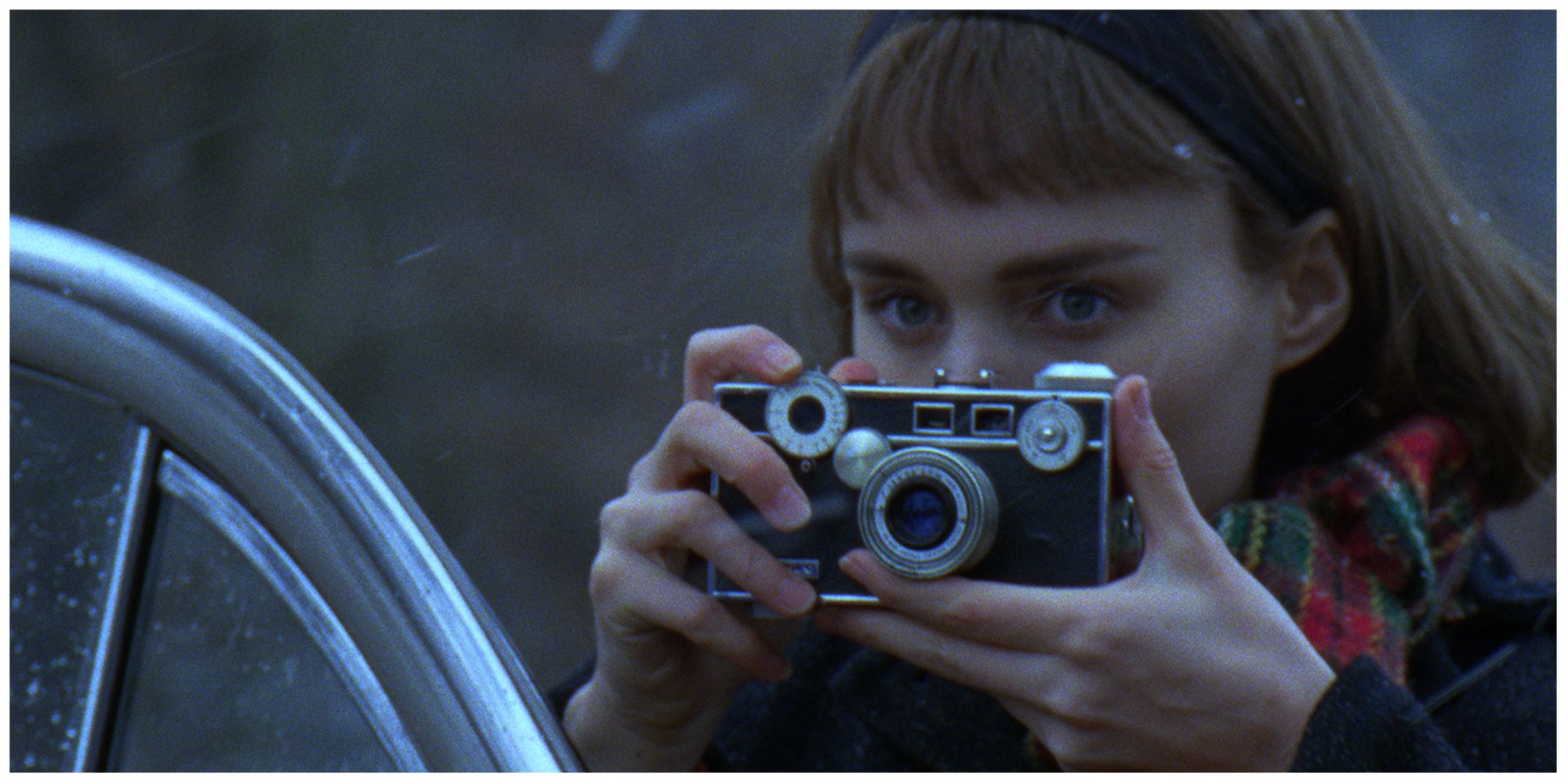 Therese taking a picture of Carol (offscreen) outside in the snow