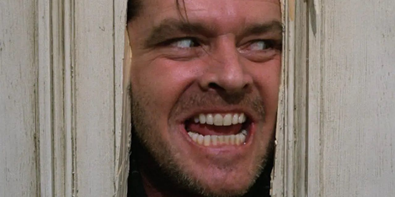 Jack looking through a hole in the bathroom door in The Shining