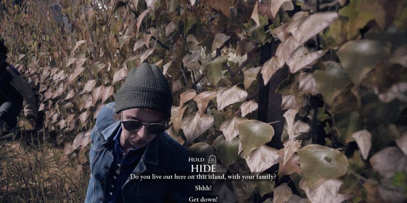 Kate and Jamie hiding during a tutorial prompt in The Devil in Me 