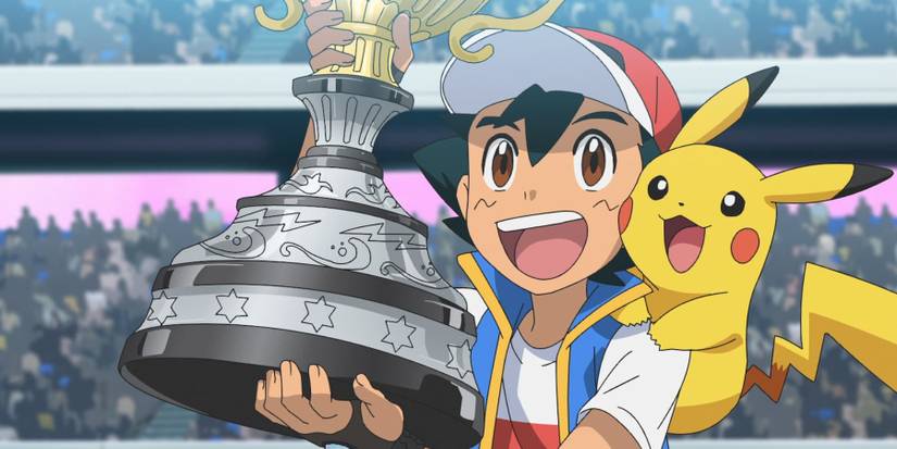 ash ketchum lifting the pokemon world champion trophy with pikachu on his shoulder