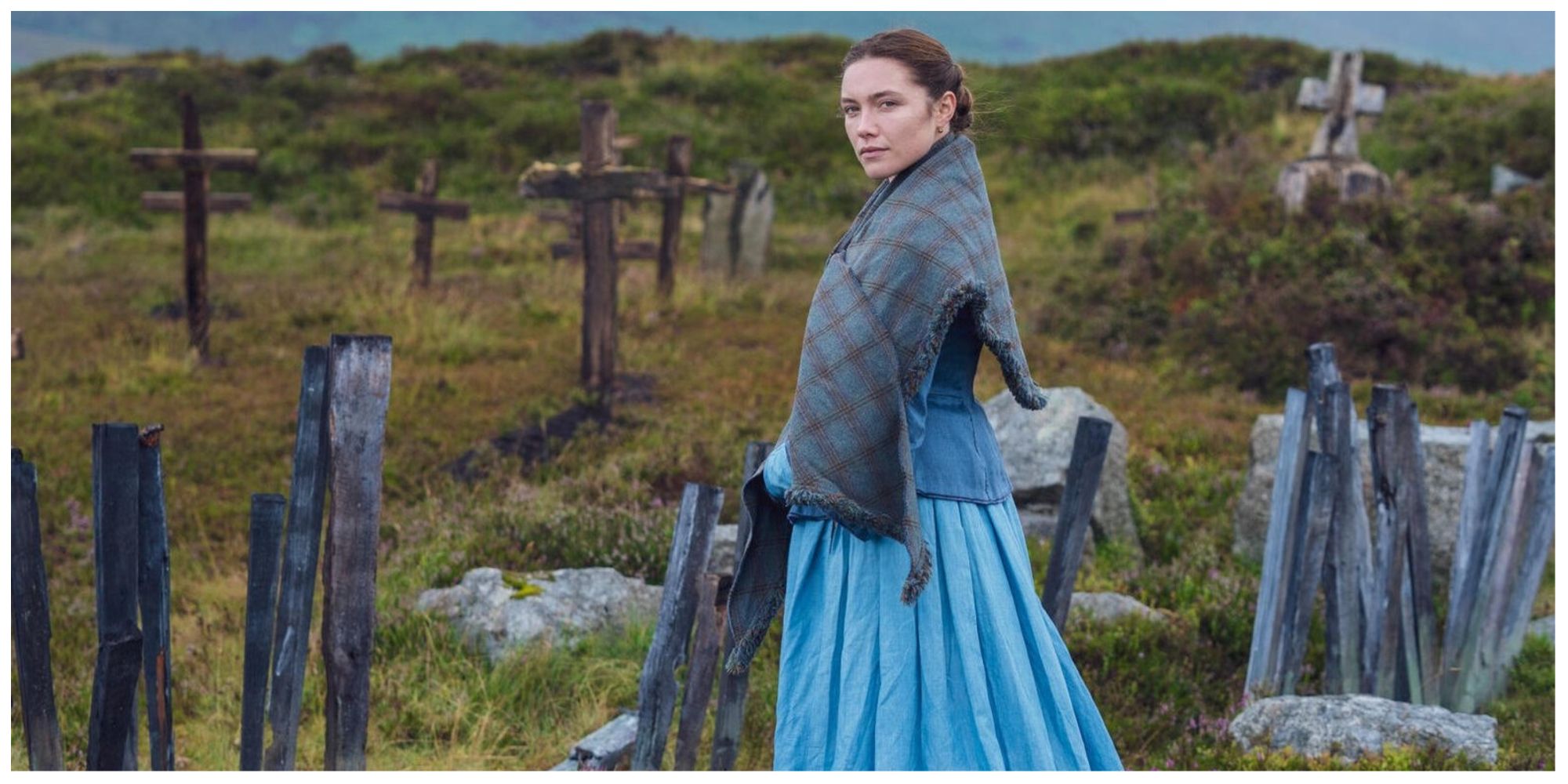 Florence Pugh in 'The Wonder' stood in a graveyard in the Scottish landscape 