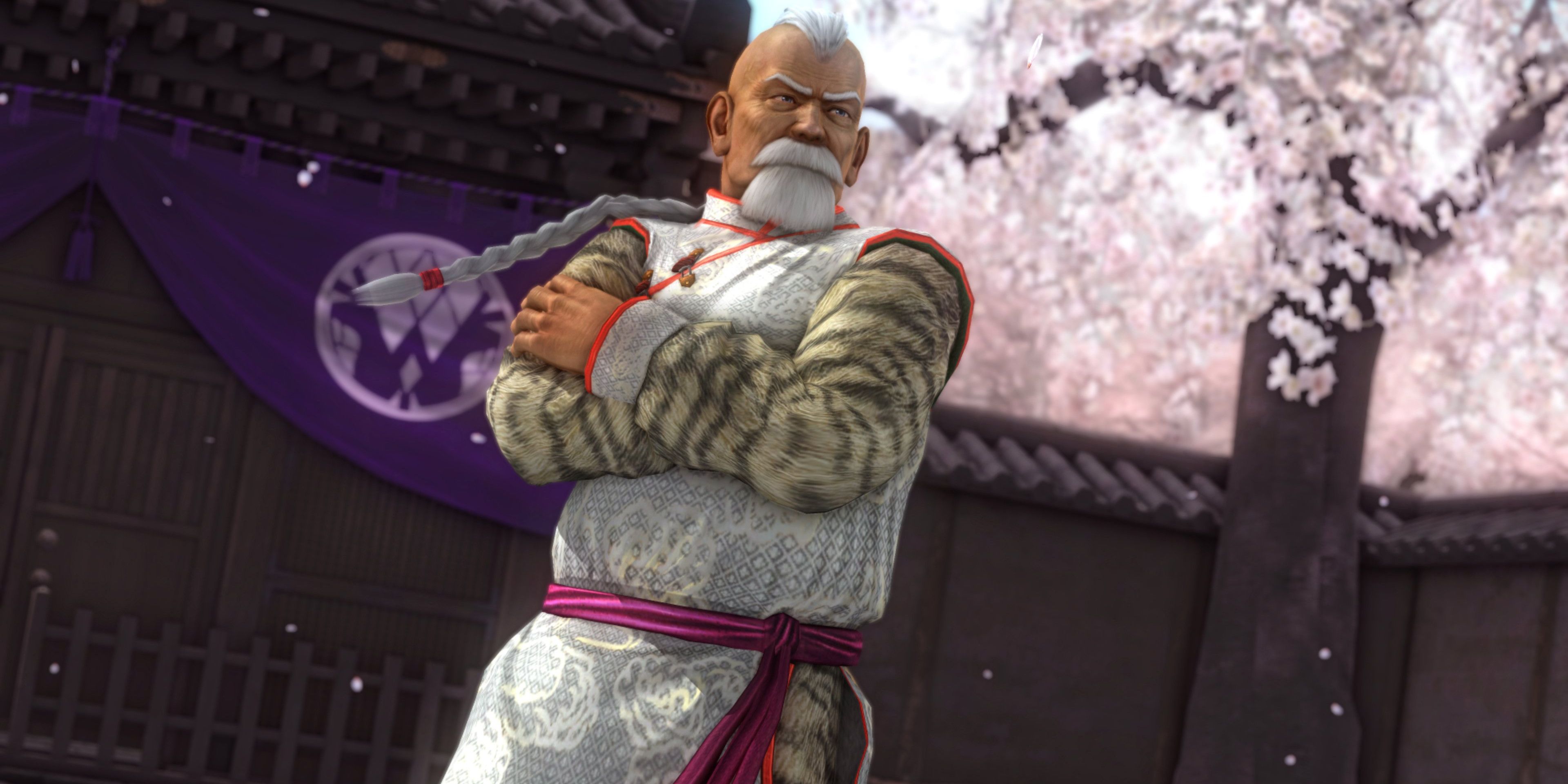 Gen Fu, an elder Chinese men in traditional fight gi with cherry blossoms behind him
