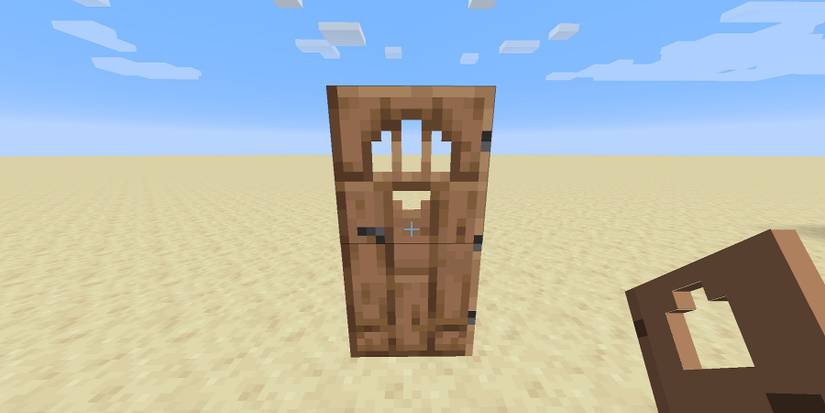 Screenshot from Minecraft showing a wooden door in the middle of a flat desert plain.
