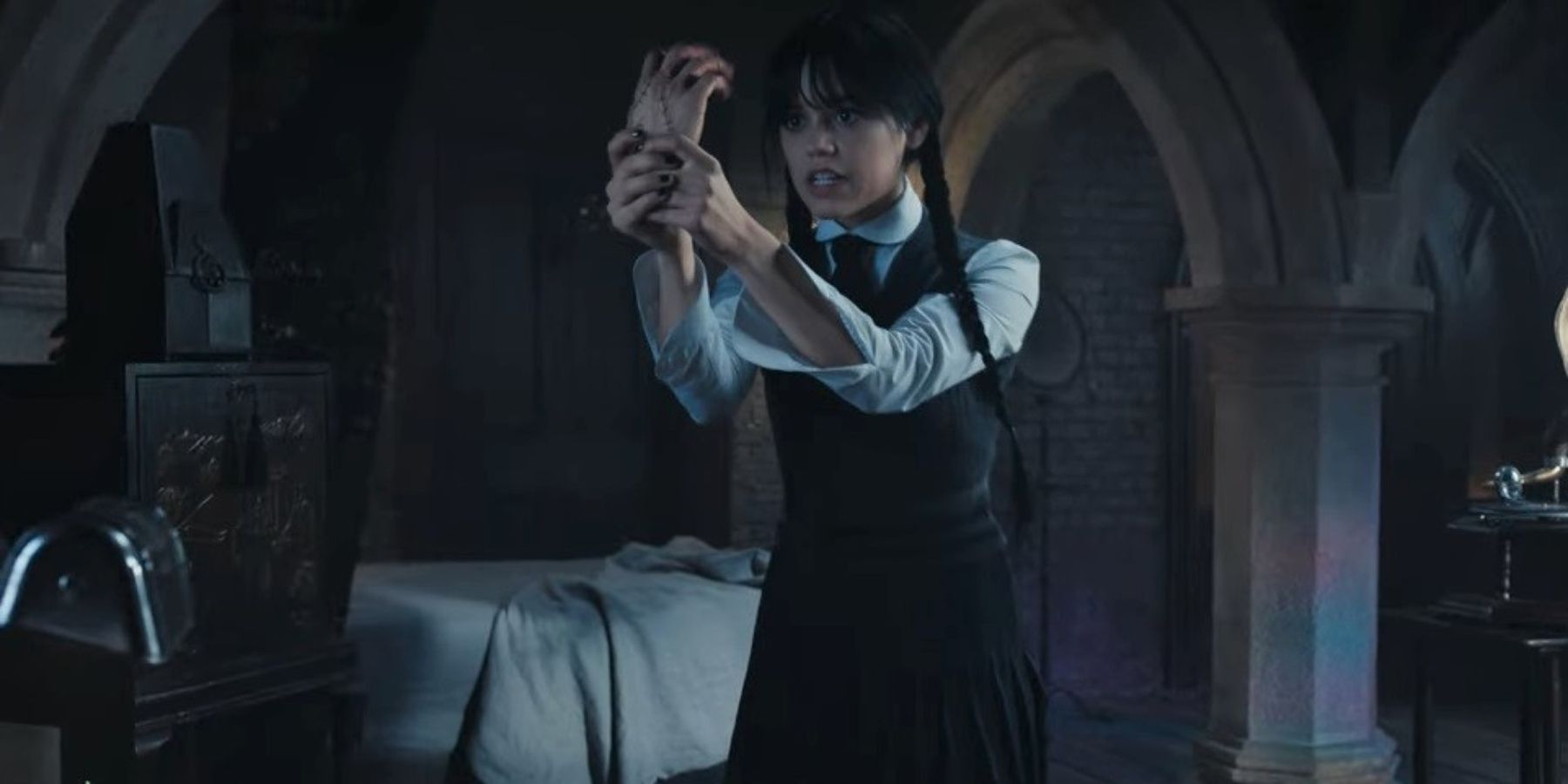 Jenna Ortega as Wednesday holding Thing in Wednesday