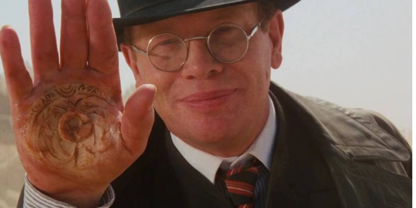 arnold toht holding his hand up