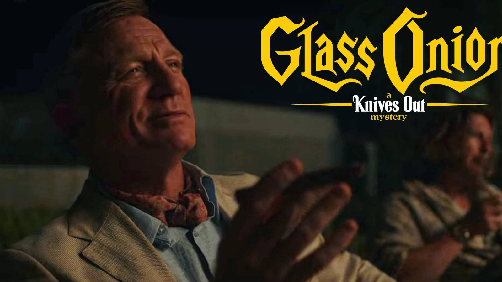 Daniel Craig as Benoit Blanc celebrating with Knives Out: A Glass Onion Mystery logo