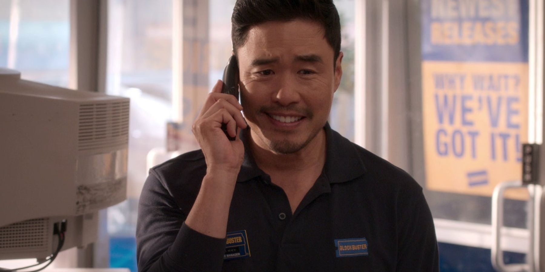 Timmy Yoon (Randall Park) talking on the phone in Blockbuster