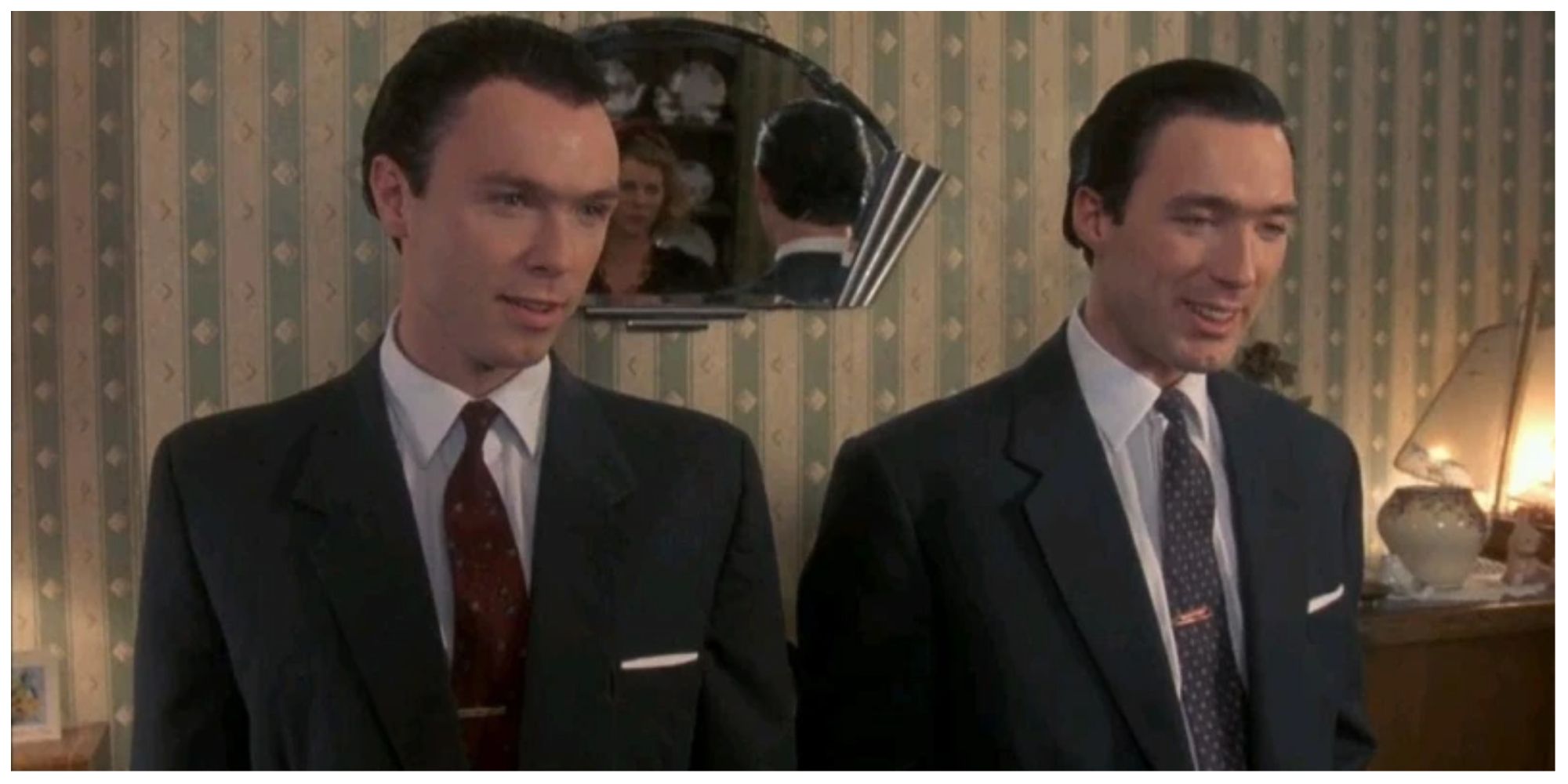 Gary and Martin Kemp starring as The Kray Twins, stood in a living room smiling at their Mother.