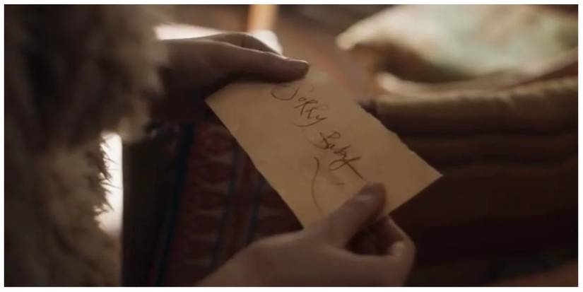 Eve (offscreen) holding a handwritten note that reads "sorry baby x"