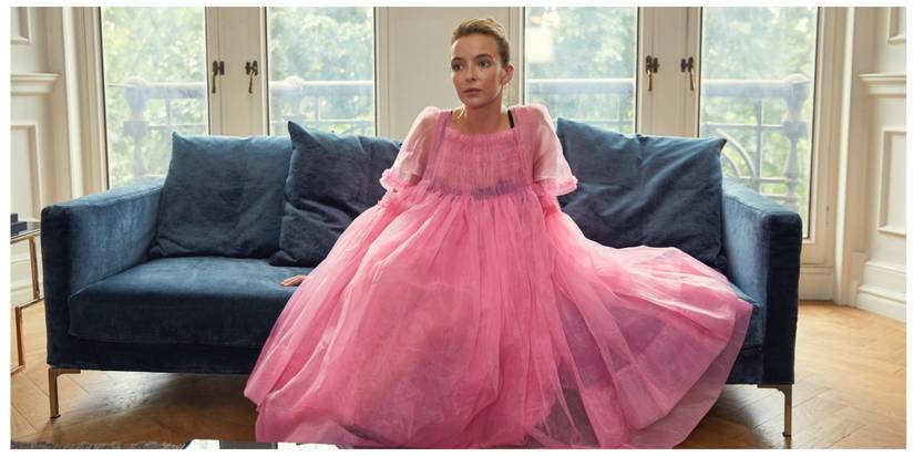 Villanelle sat looking bored in the iconic pink dress on a blue sofa at a therapist's office.