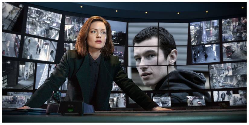 Detective Rachel from The Capture standing in the observation room with Shaun on the screens in the background