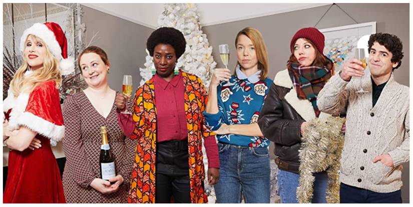 The cast of Motherland smiling and holding glasses of prosecco dressed in Christmas clothing 