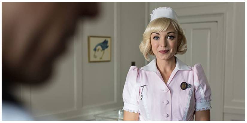 Nurse Franklin standing in her nurses uniform at work smiling at a character off screen