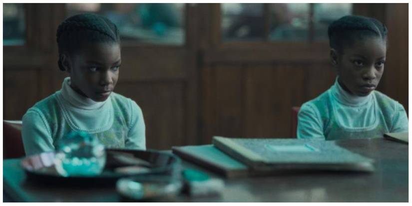 The so-called silent twins sat at a desk as children looking at something off screen