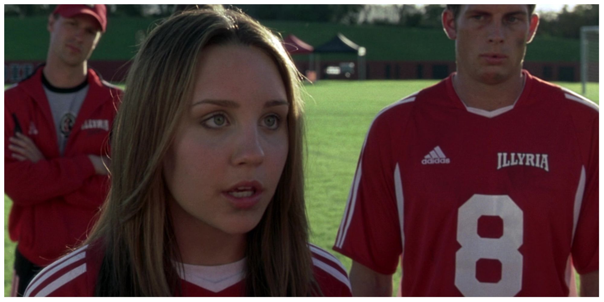 Amanda Bynes as Viola in She's The Man stood on the football pitch with her teammates.