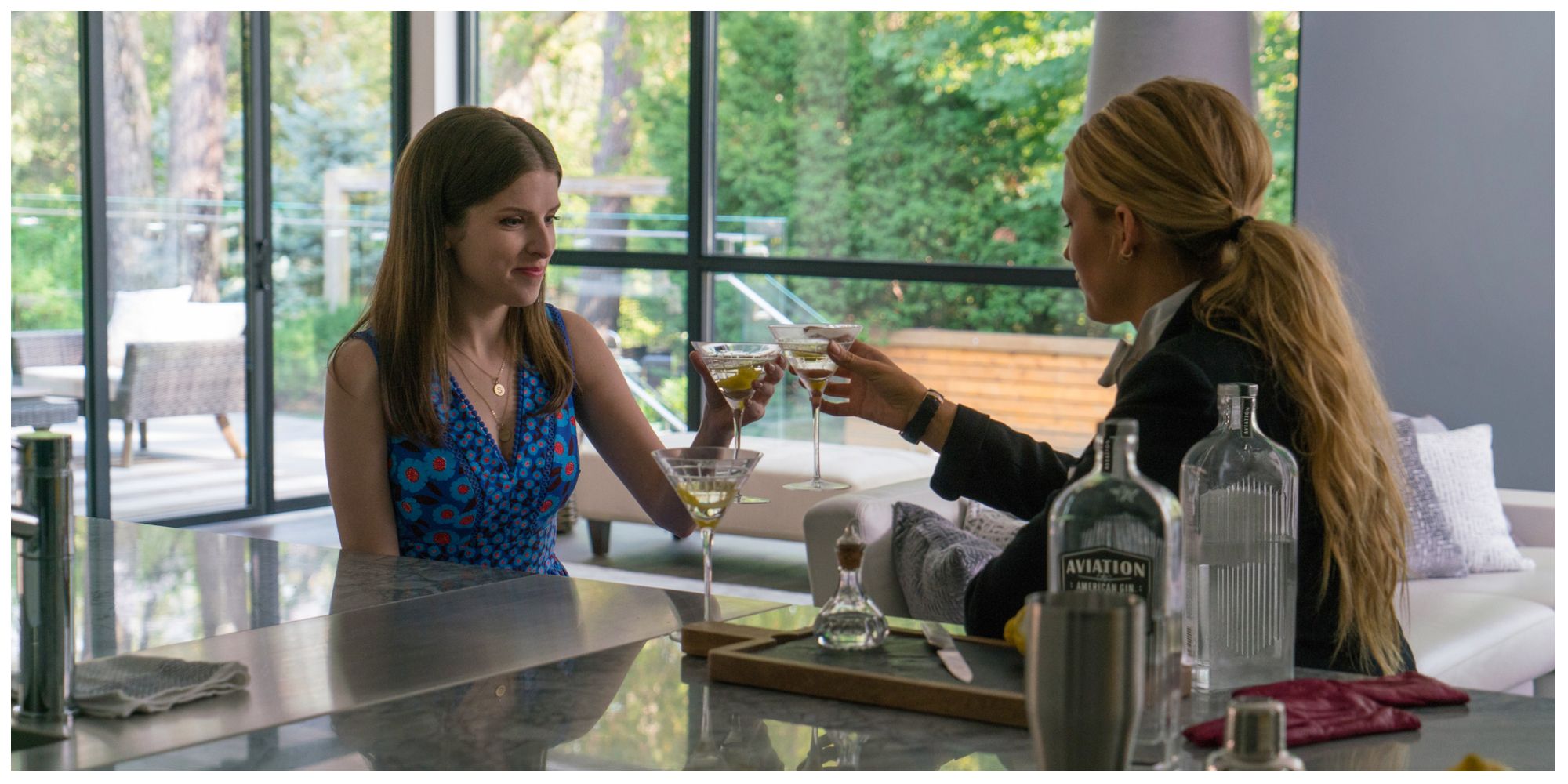 Stephanie and Emily clinking their cocktail glasses together in Emily's kitchen