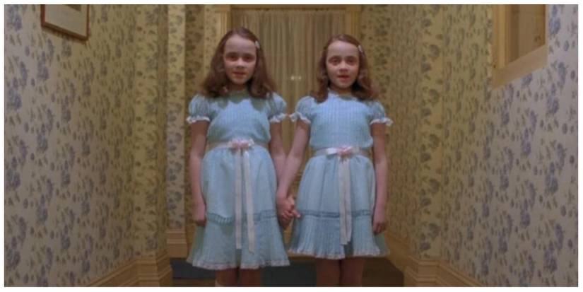 The Grady Twins in the iconic hallway scene stood together holding hands