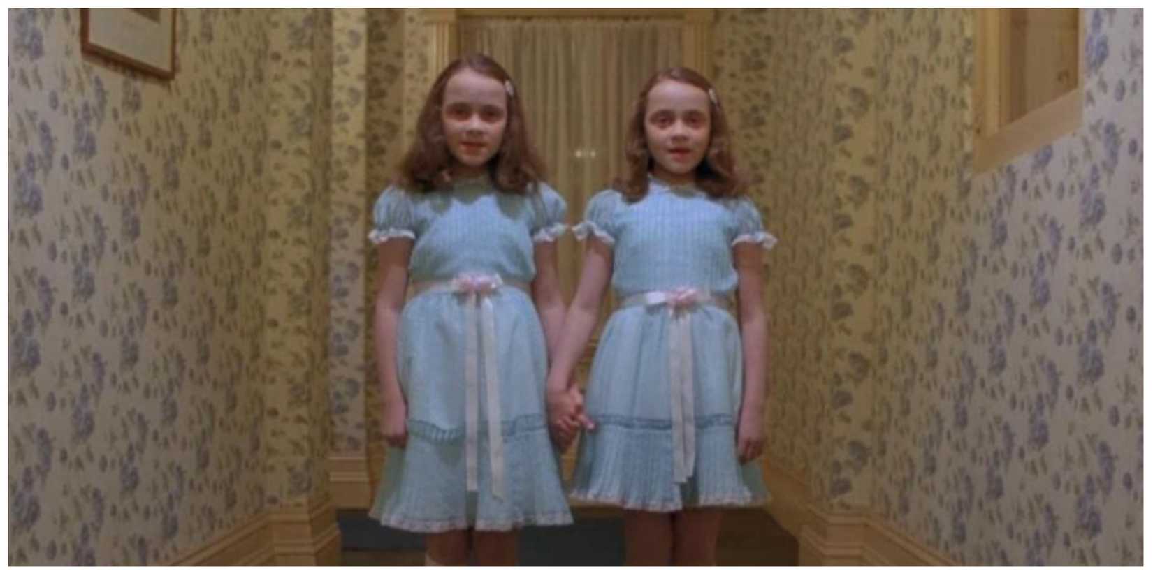 The Grady Twins in the iconic hallway scene stood together holding hands