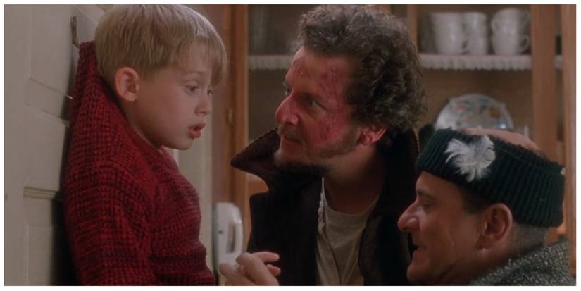 Kevin hanging by his jumper as the burglars interrogate him in his house