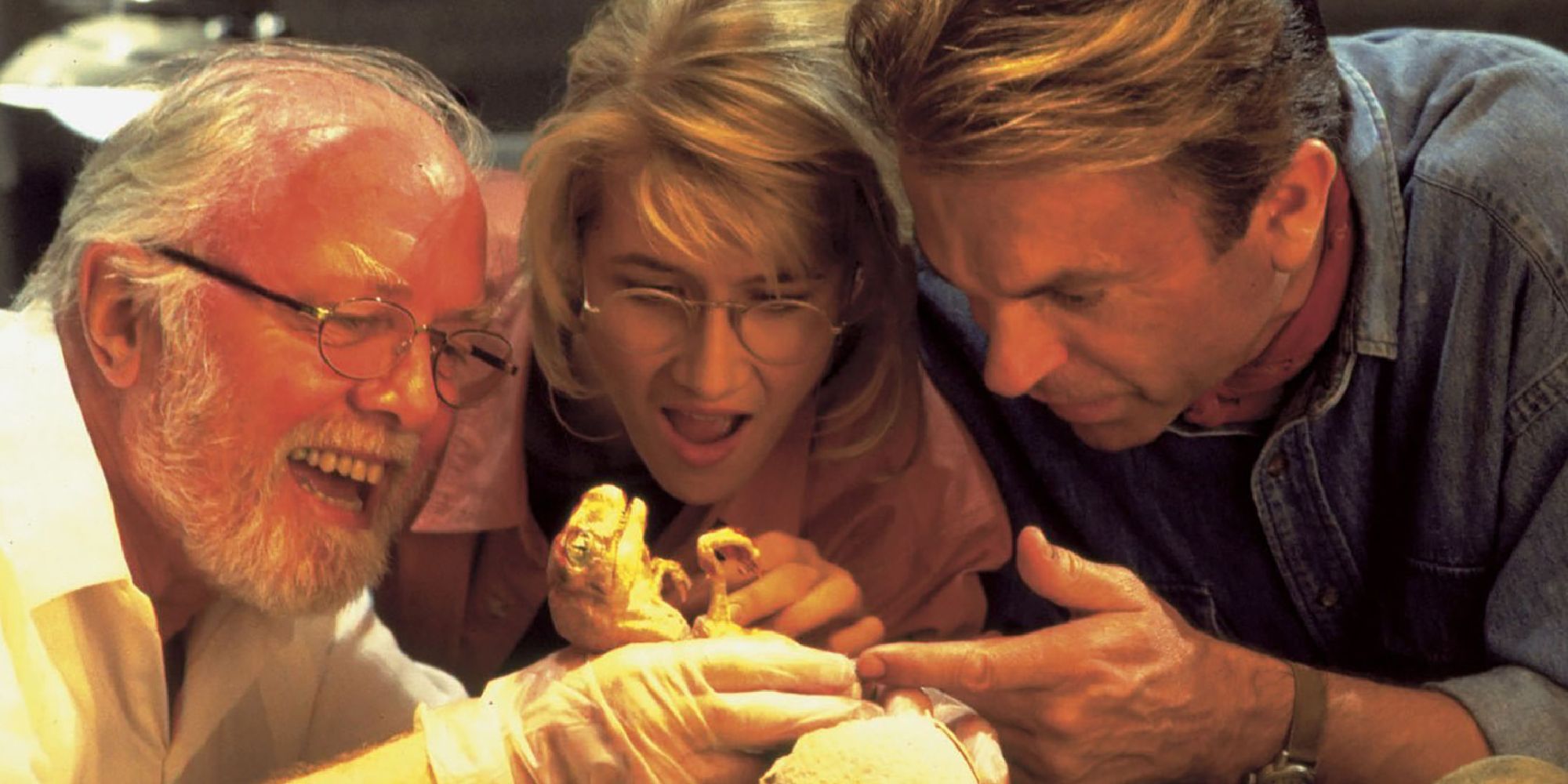 Sam Neill, Laura Dern, and Richard Attenborough with a baby dinosaur in Jurassic Park