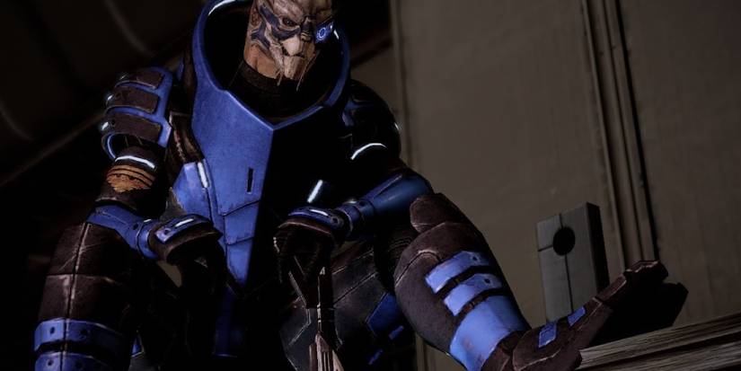 Garrus from Mass Effect 2 sitting with one foot propped up, resting his hand on his trusty sniper rifle