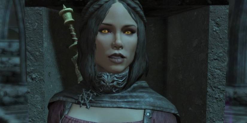 Serana looks straight at the viewer as she standing in front of a stone dungeon at night