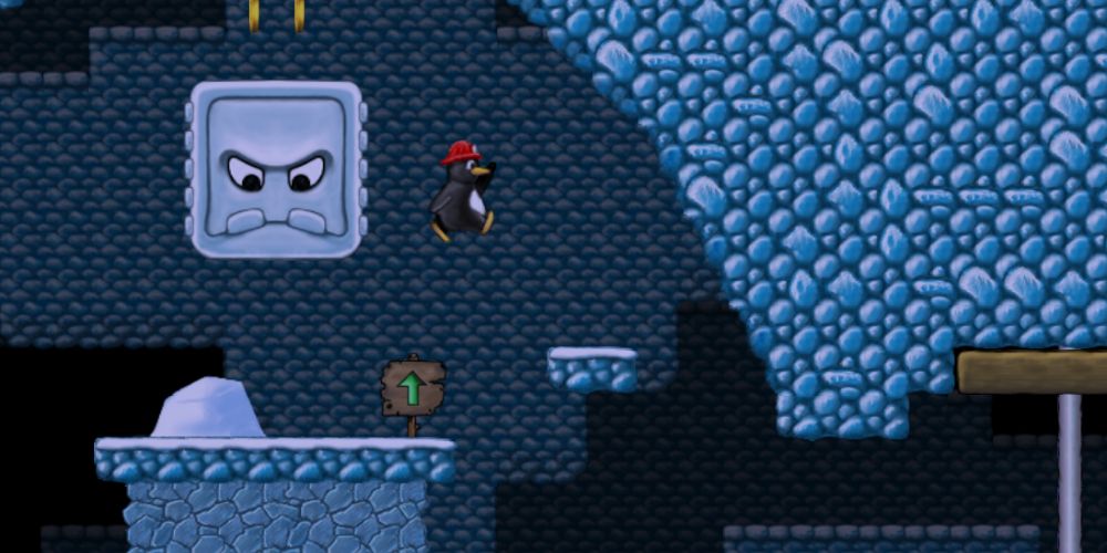 A penguin wearing a firefighter hat leaping a chasm in an undergroudn cavern before a stone block with an angry face falls on him. Image source: supertux.org.