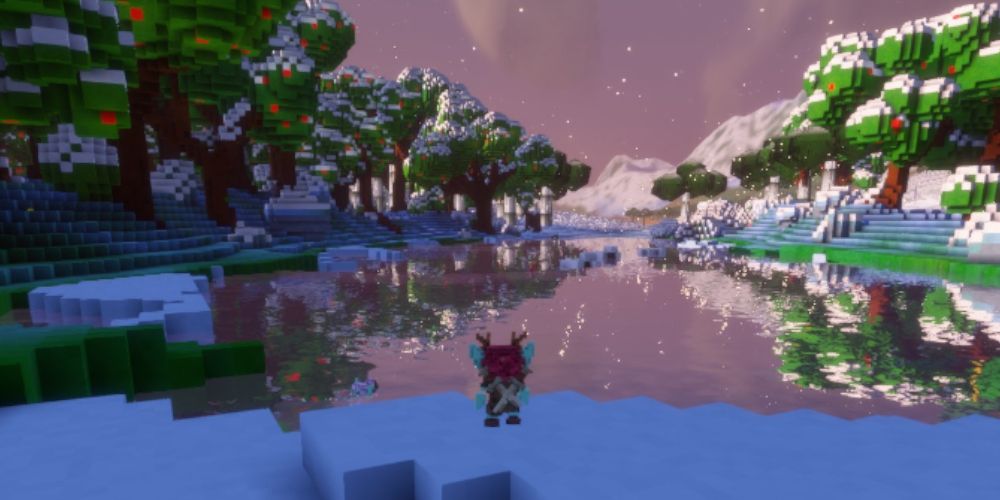 A blue elf with antlers at the edge of a lake, surrounded by trees and snowy mountains.