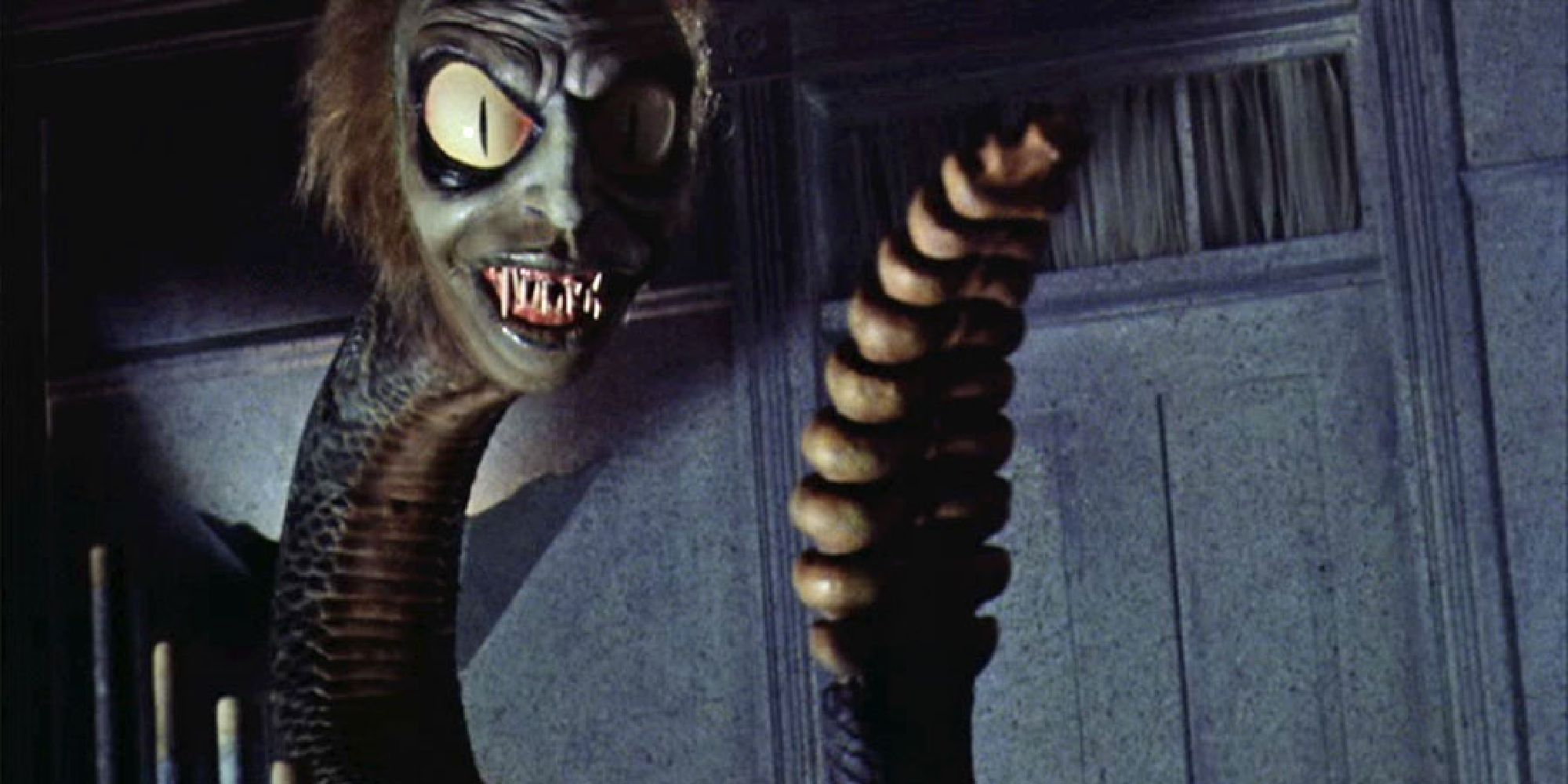 Beetlejuice's sandworm from he movie, a snake-like creature with a rattle tail and distorted, grinning face.