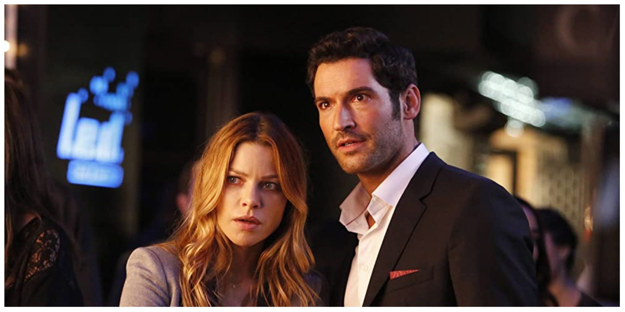 Lucifer standing with Chloe in the hit show Lucifer, as they look concerned with something off screen.