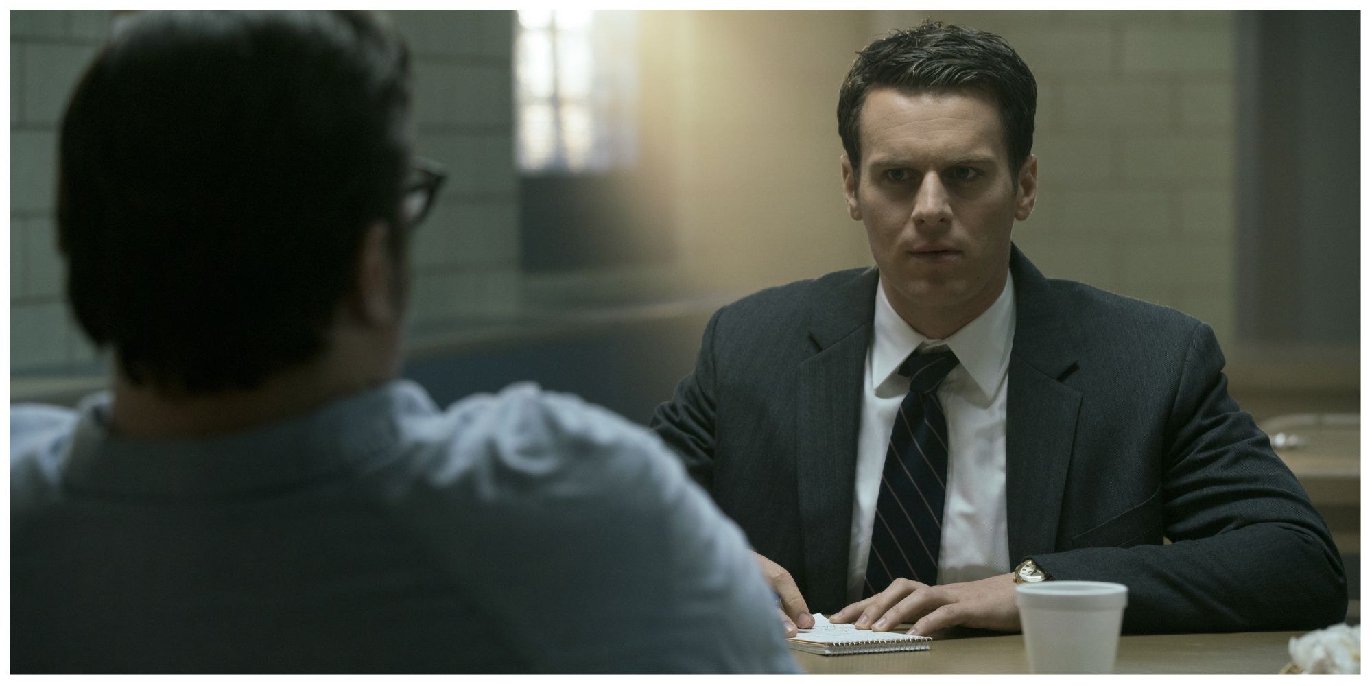Holden Ford in Mindhunter interrogating someone with a serious expression
