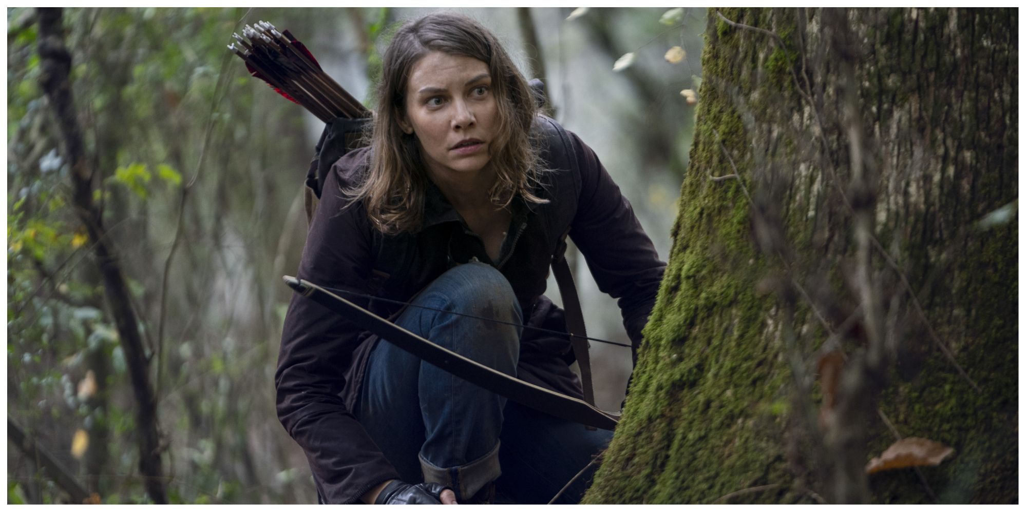 Maggie from The Walking Dead crouching behind a tree with a bow and arrow