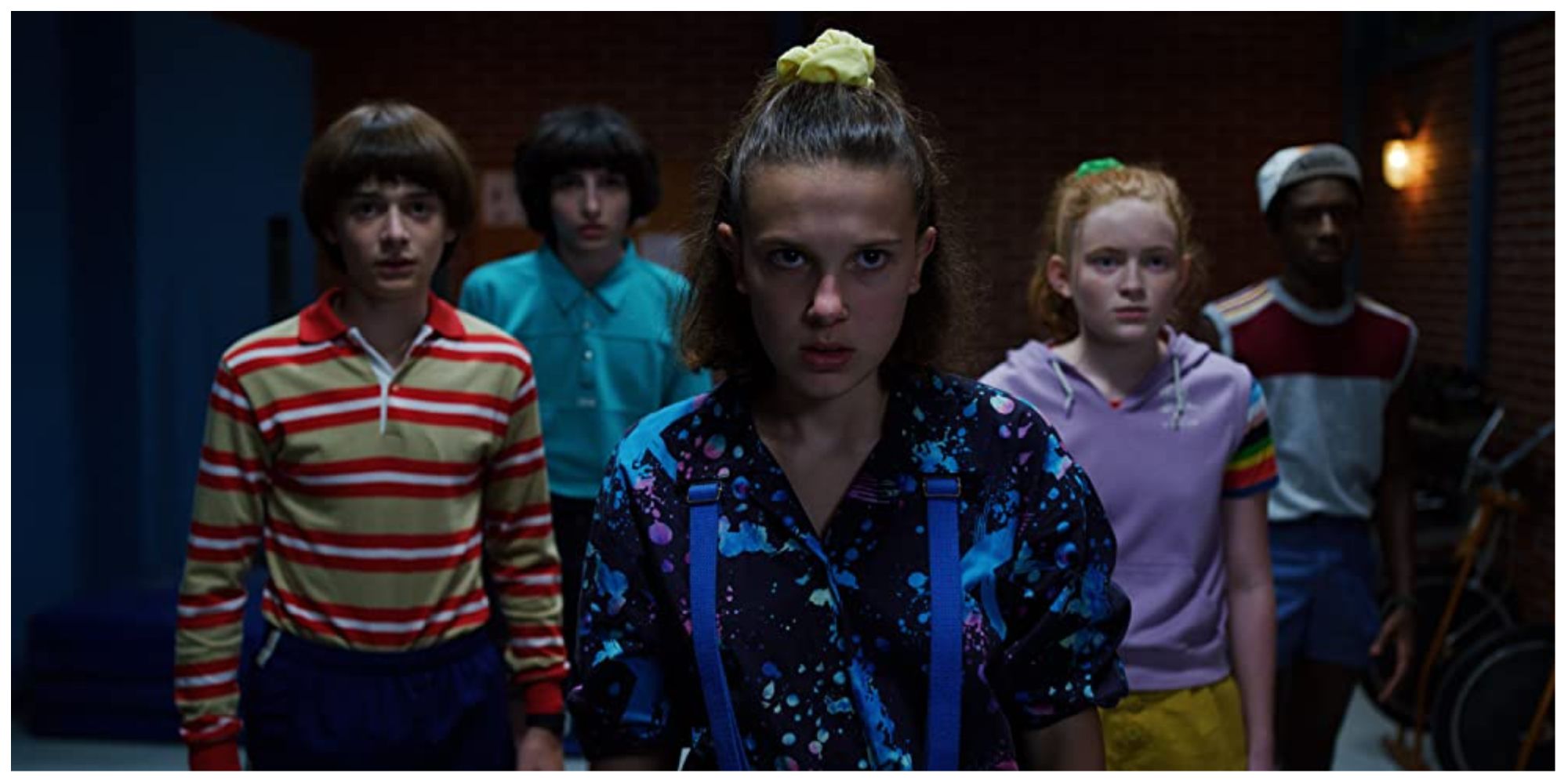 From left to right: Will, Mike, Eleven, Max and Lucas facing the villain (offscreen) in Stranger Things looking both angry and scared