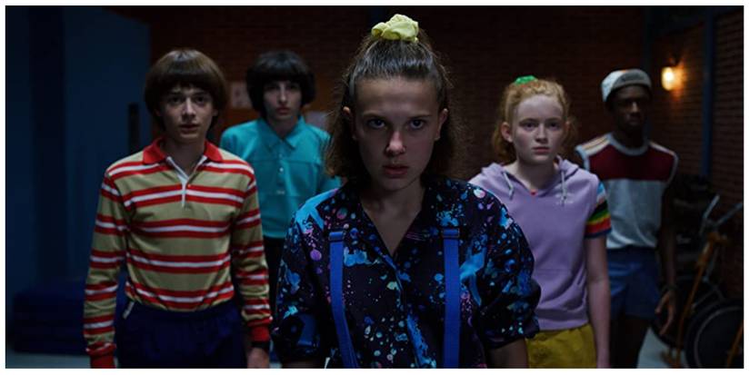 From left to right: Will, Mike, Eleven, Max and Lucas facing the villain (offscreen) in Stranger Things looking both angry and scared