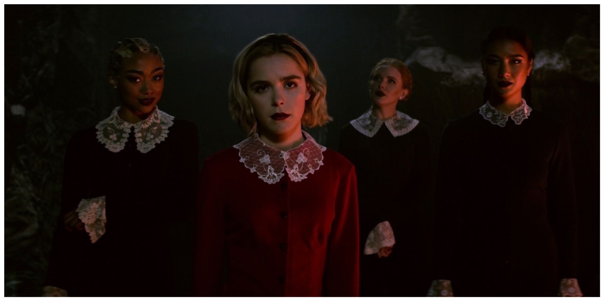 Sabrina stood at her Dark Baptism looking stern with supporting cast members, fellow classmates, stood behind her