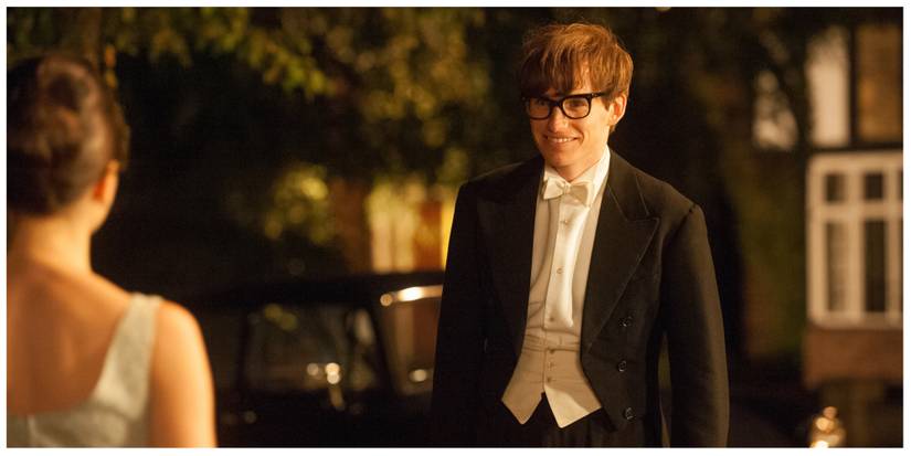 Eddie Redmayne as Stephen Hawking stood smiling at his future wife (offscreen)