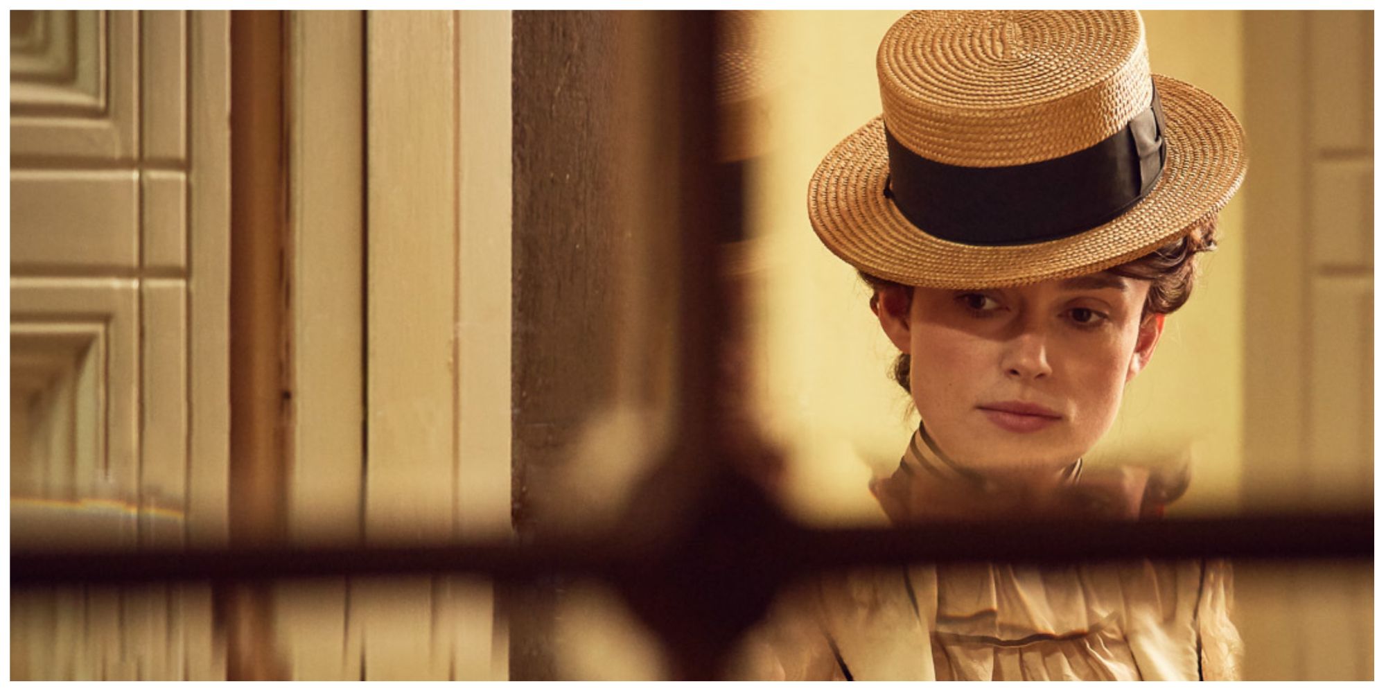 Keira Knightley as Colette looking through a window pensively 