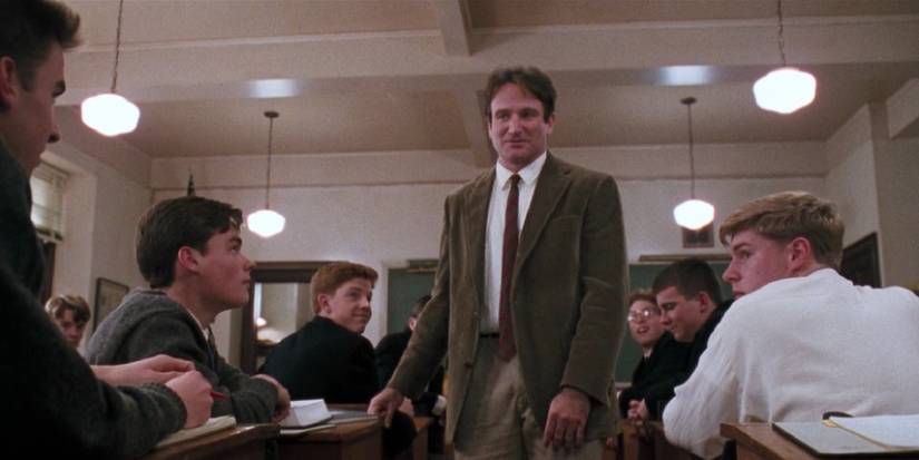 John Keating walking between desks as he addresses his enthralled class in Dead Poets Society.