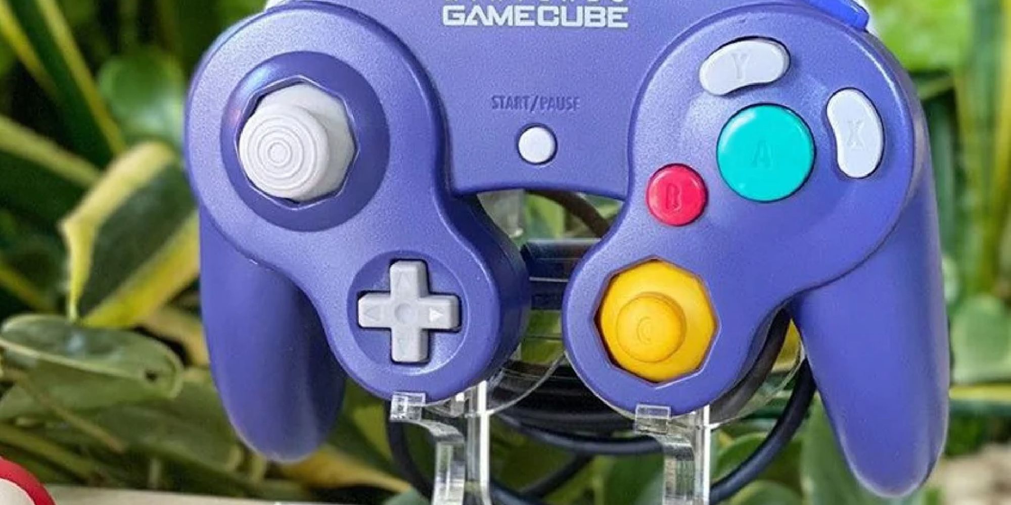 A GameCube controller resting on a plastic stand