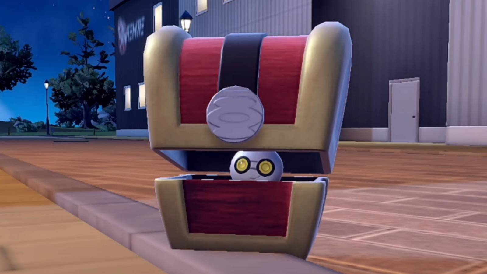 Gimmighoul hides in its chest with a building in the background.